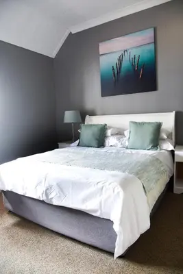 a bedroom with a large white bed with blue pillows at Constantia Hotel and Conference Centre in Midrand