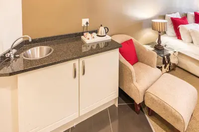a bathroom with a sink and a couch at Constantia Hotel and Conference Centre in Midrand