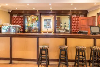 a bar with stools in a restaurant at Constantia Hotel and Conference Centre in Midrand