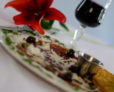 a plate of food next to a glass of wine at Hotel @ Tzaneen in Tzaneen