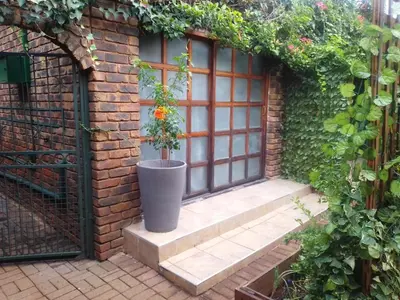 a brick wall with a window with a potted plant at 8 Soenie Avenue Self-Catering in Pretoria