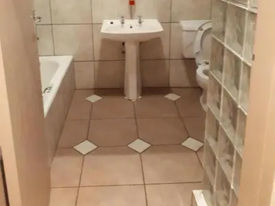 a bathroom with a sink and a tub and a toilet at 8 Soenie Avenue Self-Catering in Pretoria