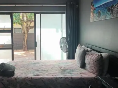 a bedroom with a bed and a large window at 8 Soenie Avenue Self-Catering in Pretoria