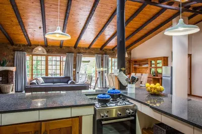 a kitchen with a stove and a living room at Rivendell Trout Estate in Lydenburg