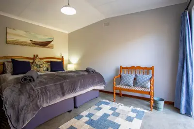 a bedroom with a bed and a crib and a chair at Rivendell Trout Estate in Lydenburg