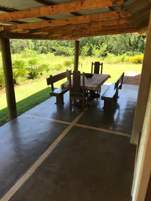 a wooden table and chairs on a patio at Featherbrook Cottage in Tzaneen