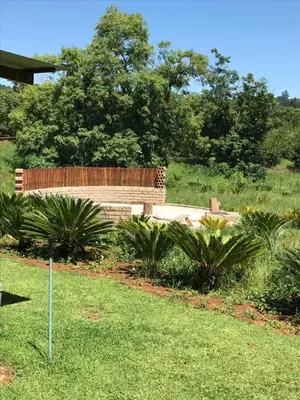a park with a wooden bench in the grass at Featherbrook Cottage in Tzaneen