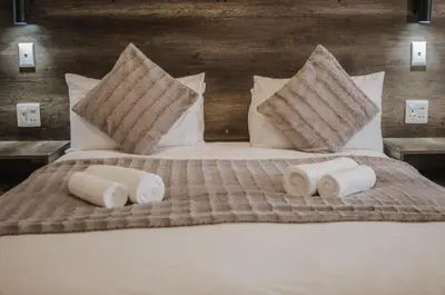 a bed with two rolled towels on top of it at Casa Leitao Lodge in Phalaborwa