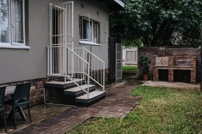 a house with a staircase and a table and chairs at Casa Leitao Lodge in Phalaborwa