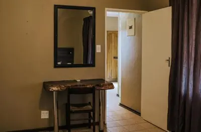 a room with a counter and a mirror on the wall at Casa Leitao Lodge in Phalaborwa