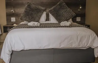 a bedroom with a large bed with towels on it at Casa Leitao Lodge in Phalaborwa