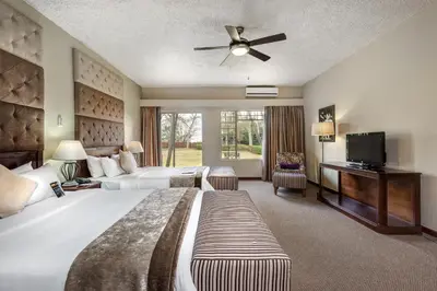 a hotel room with a large bed and a flat screen tv at Hazyview Sun in Hazyview