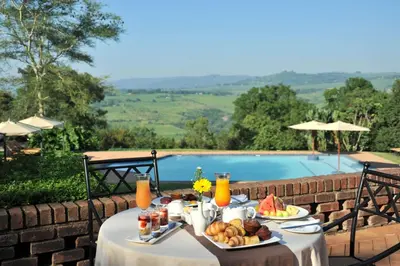 a table with a plate of food next to a pool at Hazyview Sun in Hazyview