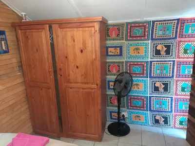 a room with a wooden cabinet and a tile wall at 1322 Backpackers International in Pretoria