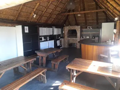 a restaurant with wooden tables and a kitchen at 1322 Backpackers International in Pretoria