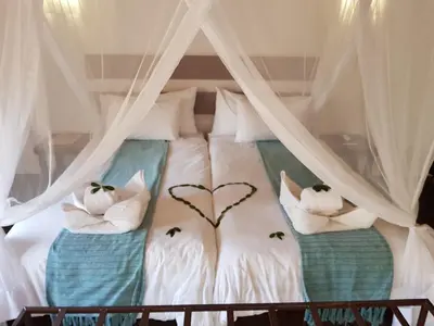a bed with two pillows with a heart on it at Boulders Safari Lodge in Malelane