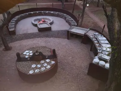 a backyard with a fire pit and a table and benches at Boulders Safari Lodge in Malelane