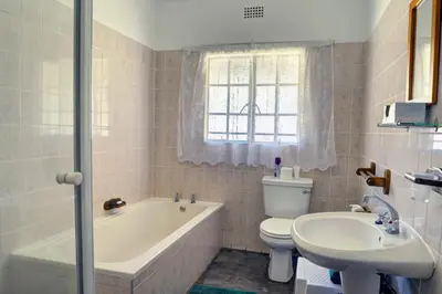 a bathroom with a tub and a toilet and a sink at Komati River Chalets in Komatipoort