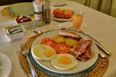 a plate of breakfast food with eggs and tomatoes on a table at Komati River Chalets in Komatipoort