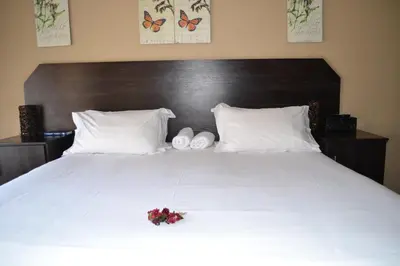 a bedroom with a white bed with flowers on it at Oasis Of Life Guest House in Witbank