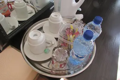 a tray with cups and bottles of water on a table at Oasis Of Life Guest House in Witbank