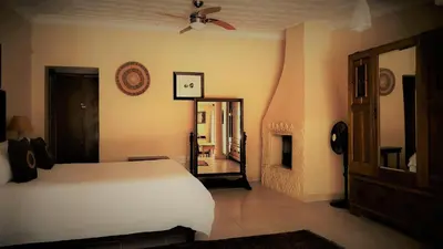 a bedroom with a white bed and a mirror at African Roots Guest House in Polokwane