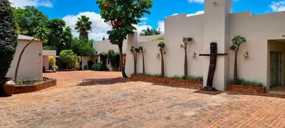 a church with a cross on a brick road at African Roots Guest House in Polokwane