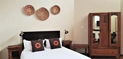 a bedroom with a bed and two plates on the wall at African Roots Guest House in Polokwane