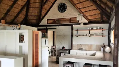 a kitchen with a table and a clock on the ceiling at Graceland Eco Retreat in Magoebaskloof