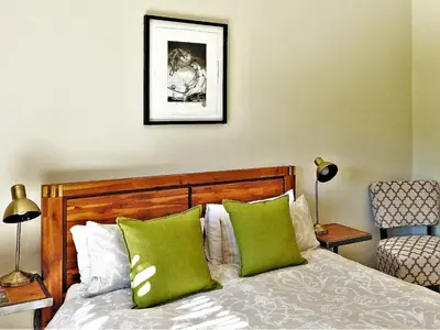 a bedroom with a bed with two green pillows at Graceland Eco Retreat in Magoebaskloof