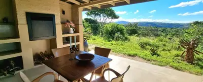 a table and chairs in a room with a view at Graceland Eco Retreat in Magoebaskloof
