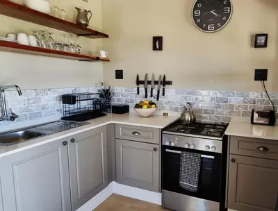 a kitchen with a stove and a clock on the wall at Graceland Eco Retreat in Magoebaskloof