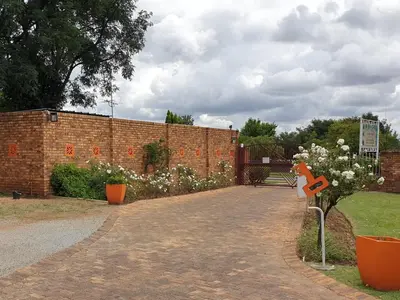 a brick wall with flowers in a garden at The Lazy Grape Guest Lodge & Spa in Benoni
