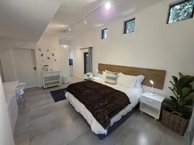 a bedroom with a large bed and a bathroom at 440@Brooklyn in Pretoria