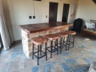 a stone bar with stools in a room at Dream Of Nature in Bela-Bela