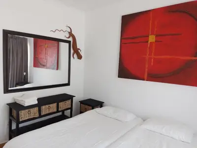 a bedroom with two beds and a large painting on the wall at Anna Boeremeisie Guesthouse in Benoni