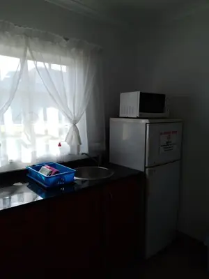 a kitchen with a microwave on top of a refrigerator at Anna Boeremeisie Guesthouse in Benoni