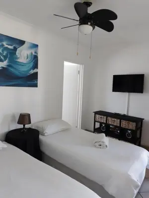 a bedroom with two beds and a ceiling fan at Anna Boeremeisie Guesthouse in Benoni