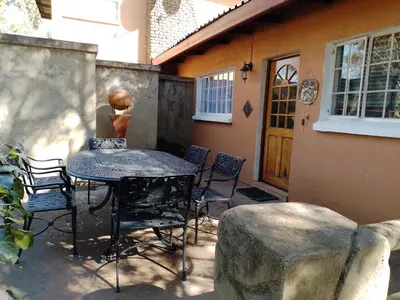 a patio with a table and chairs in front of a house at Anna Boeremeisie Guesthouse in Benoni
