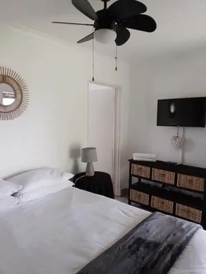 a bedroom with a bed and a ceiling fan at Anna Boeremeisie Guesthouse in Benoni
