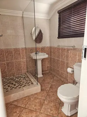 a bathroom with a shower and a toilet and a sink at TCS on Lynnwood Guesthouse in Pretoria