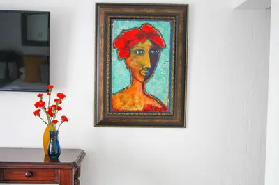 a painting of a woman with a red hat on a wall at TCS on Lynnwood Guesthouse in Pretoria