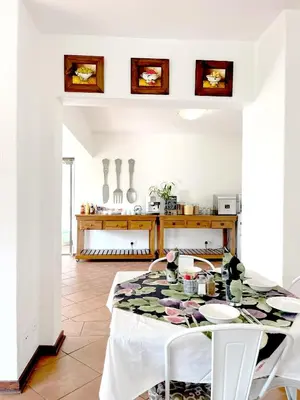 a dining room with a table and a kitchen at TCS on Lynnwood Guesthouse in Pretoria