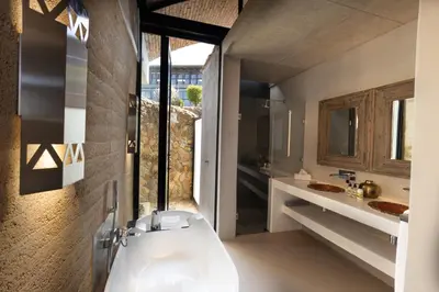 a bathroom with a white tub and two sinks at Angels View Hotel in Graskop