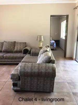 a living room with two couches and a couch at Impala Chalets in Phalaborwa