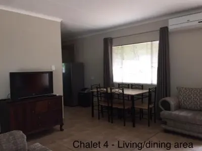 a living room with a table and a dining room at Impala Chalets in Phalaborwa