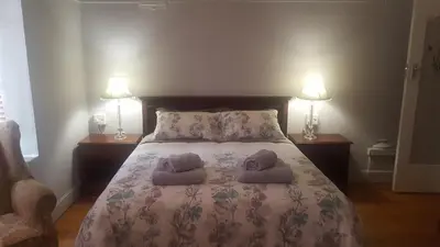 a bedroom with a bed with two pillows and two lamps at Pretoria Inn in Pretoria