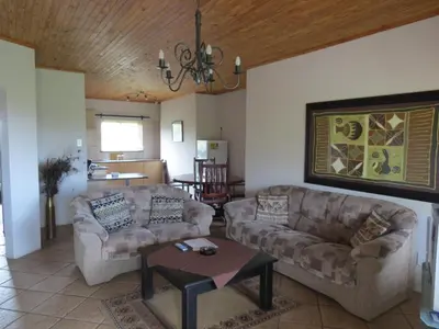 a living room with two couches and a table at Crocodile Lodge cc in Midrand