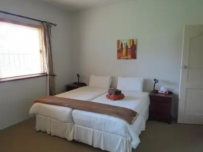 a teddy bear sitting on a bed in a bedroom at Crocodile Lodge cc in Midrand