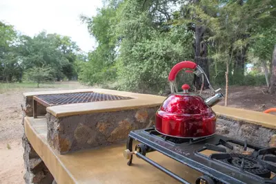 a red tea kettle on top of a grill at Southern Sands Eco Lodge in Hoedspruit